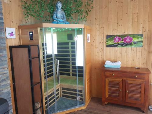 a shower in a room with a wooden wall at spacieuse maison de ville avec espace détente in Rezé