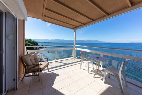 a balcony with chairs and a table and a view of the ocean at Melis Hotel Kusadasi in Kusadası