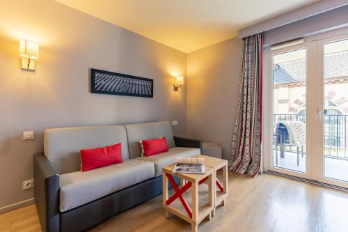 a living room with a couch and a table at Résidence Pierre & Vacances La Petite Venise in Colmar