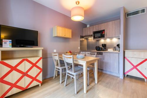 a kitchen and dining room with a table and chairs at Résidence Pierre & Vacances La Petite Venise in Colmar