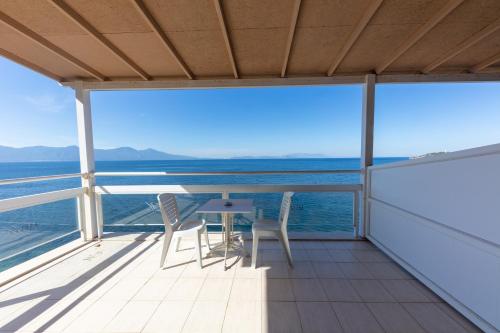 a balcony with a table and chairs overlooking the ocean at Melis Hotel Kusadasi in Kusadası