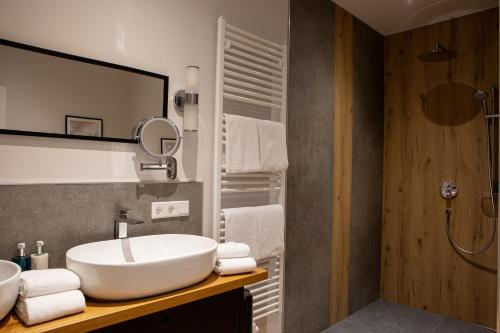 a bathroom with a sink and a shower at Romantik Hotel Aquarium in Friedrichstadt