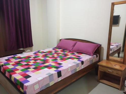 een slaapkamer met een bed met een kleurrijk dekbed bij VERA Inn in Cherrapunji