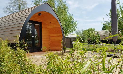 a small wooden house with a large glass door at GreenFloat Boskoop - #1 in Boskoop