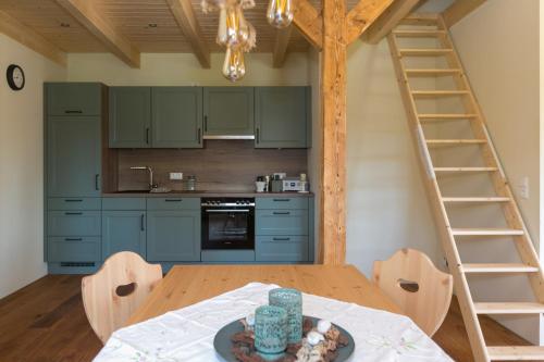 a kitchen with blue cabinets and a wooden table at Ferienhof-Eiderdeich Wohnung Hertha in Delve