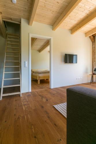 a room with a staircase and a bedroom with a bed at Ferienhof-Eiderdeich Wohnung Hertha in Delve