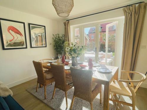 uma sala de jantar com uma mesa e cadeiras e uma janela em NEW! Beautiful contemporary property in Holt, Norfolk em Holt