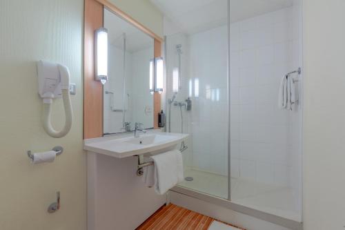 uma casa de banho com um lavatório e um chuveiro em B&B HOTEL Chartres Centre Cathédrale em Chartres