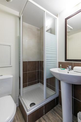 a bathroom with a shower and a sink and a toilet at Résidence Pierre & Vacances Le Clos d'Eguisheim in Eguisheim