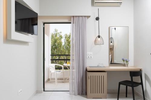 a bathroom with a desk and a mirror at Paradise Hotel Corfu in Gouvia