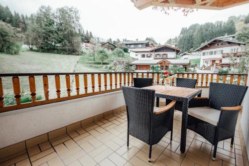 a patio with a table and chairs on a balcony at Dandler - Zimmer und Ferienwohnungen in Fieberbrunn