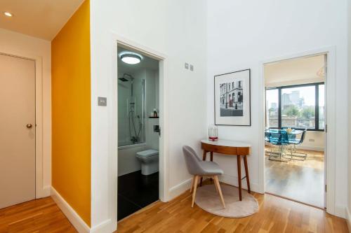 einen Flur mit einem Tisch und einem WC in einem Zimmer in der Unterkunft Mulberry South Penthouse by City Living London in London