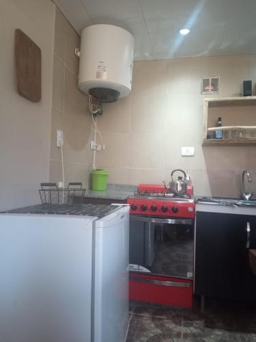 a kitchen with a stove and a red stove top oven at Aguaribay cabañas in San Javier