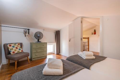 een slaapkamer met een bed, een stoel en een spiegel bij Alfama 2BDR Duplex Apartment W/ Balcony by LovelyStay in Lissabon