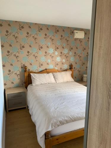 ein Schlafzimmer mit einem Bett mit blauen und braunen Tapeten in der Unterkunft Arkenfield farm cabin in East Bridgford