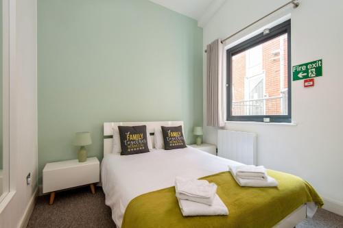 um quarto com uma grande cama branca e uma janela em Mulberry North Penthouse by City Living London em Londres