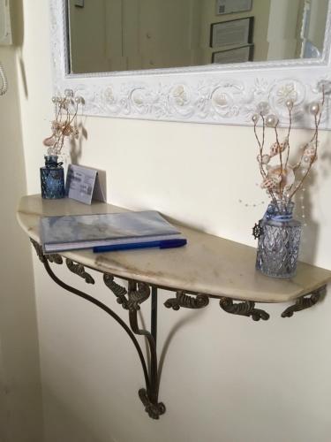 uma mesa de consola com dois vasos na frente de um espelho em Appartamento al centro di Anzio em Anzio