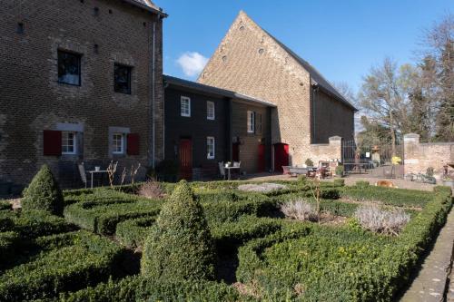 a garden in front of a brick building at Meschermolen 4 in Mesch