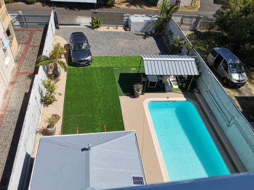 an aerial view of a yard with a swimming pool and a car at Reviva Residence in Blue Bay