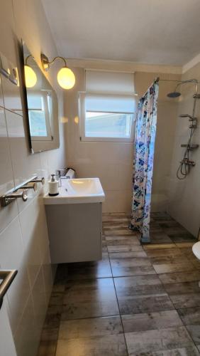 a bathroom with a sink and a mirror and a shower at La Pergola in Fažana