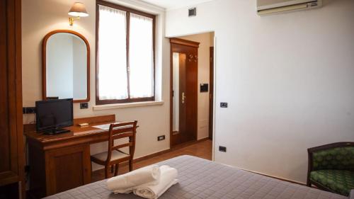 1 dormitorio con 1 cama y escritorio con TV en Bagno Santo Residence en Saturnia