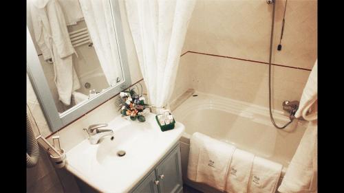 La salle de bains est pourvue d'un lavabo et d'une baignoire. dans l'établissement Bagno Santo Residence, à Saturnia