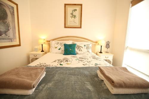 里奇蒙的住宿－Bridgecroft Villa - French Provincial in Richmond with spa，一间卧室配有一张带2个床头柜的大床