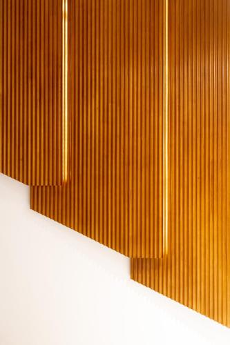 a close up of a wooden wall with lights at Volve Hotel Bangkok in Bangkok