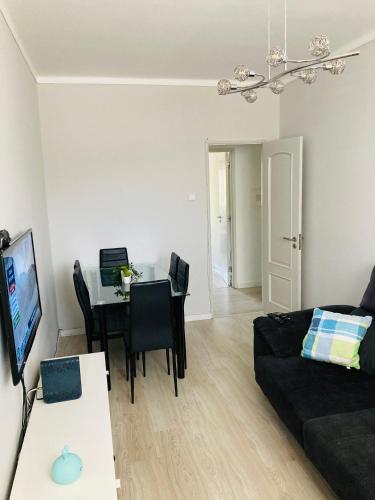 a living room with a couch and a table at Apartamento remodelado no Seixal in Seixal