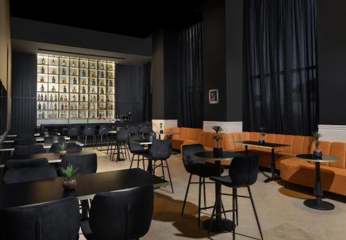 a restaurant with tables and chairs and a building at Island Luxurious Suites Hotel and Spa in Netanya
