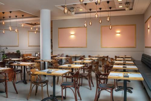 a room with tables and chairs in a restaurant at Island Luxurious Suites Hotel and Spa in Netanya