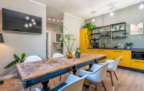 a kitchen with a wooden table and white chairs at Al Quadrato in Piobbico