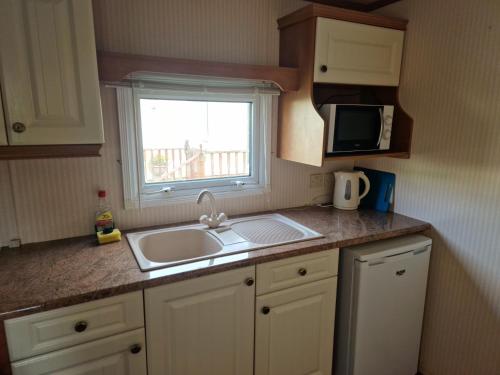 a small kitchen with a sink and a window at Willerby Shrewsbury - Pitch 51 in Welshpool