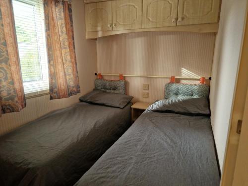 two beds in a small room with a window at Willerby Shrewsbury - Pitch 51 in Welshpool