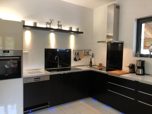 a kitchen with black and white counters and a sink at Löwenherz in Göstling an der Ybbs