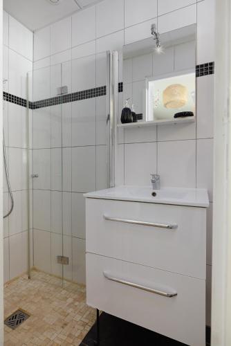 une salle de bain blanche avec un lavabo et une douche dans l'établissement Chic Parisian - 5' RER C Paris - Orly 15 min, à Savigny-sur-Orge