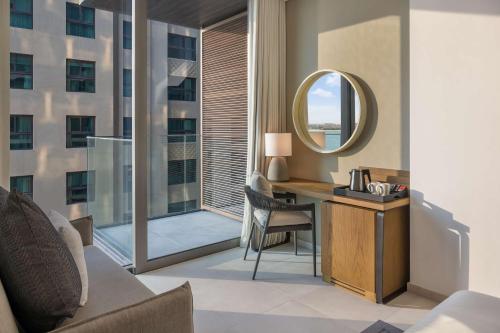 a hotel room with a desk and a mirror at Radisson Beach Resort Palm Jumeirah in Dubai