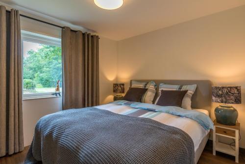 a bedroom with a bed and a large window at B&B De Oude Skuur in Oosterend