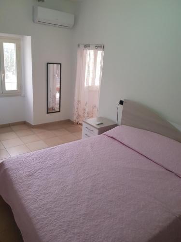 a bedroom with a large bed in a white room at LA CASETTA DI MARY in Canosa Sannita