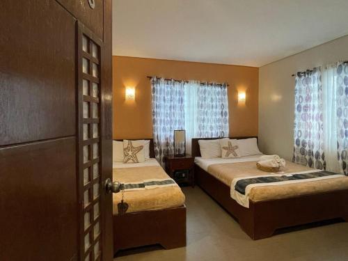 una camera d'albergo con due letti e una finestra di Casa Coron Hotel a Coron