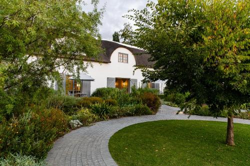 a house with a walkway in front of a yard at Erinvale Estate Hotel & Spa in Somerset West
