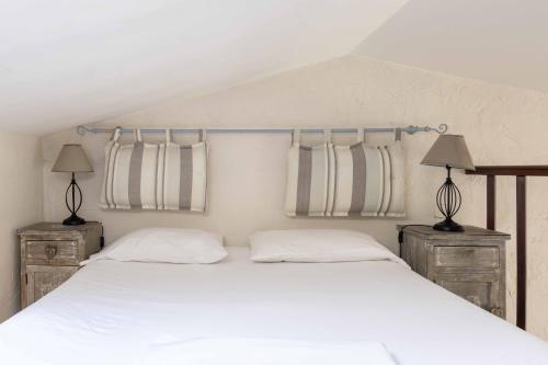 - une chambre avec un lit blanc, 2 lampes et 2 fenêtres dans l'établissement Appartements Vivo, à Cagnes-sur-Mer