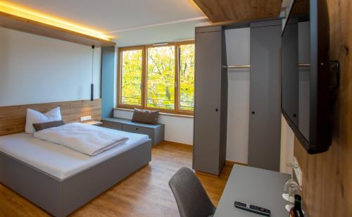 a bedroom with a bed and a flat screen tv at Kolping-Hotel in Schweinfurt