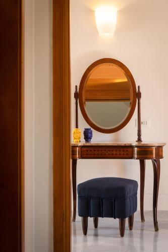 a table with a mirror and a blue stool at Il Giardino di Venere in Mondello