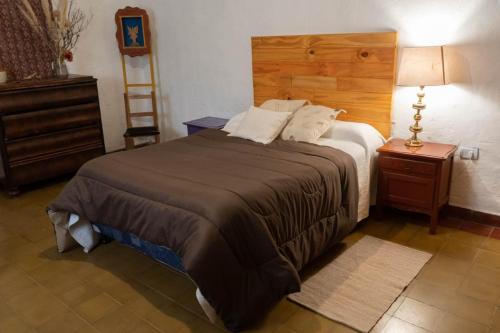 een slaapkamer met een groot bed met een houten hoofdeinde bij La Esmeralda in Amaichá del Valle