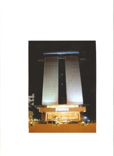a large building with a clock tower at night at Hotel President, Pure Veg in Indore