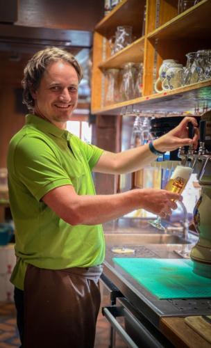 a man standing in a kitchen preparing food at Landgasthof Jostalstüble in Titisee-Neustadt