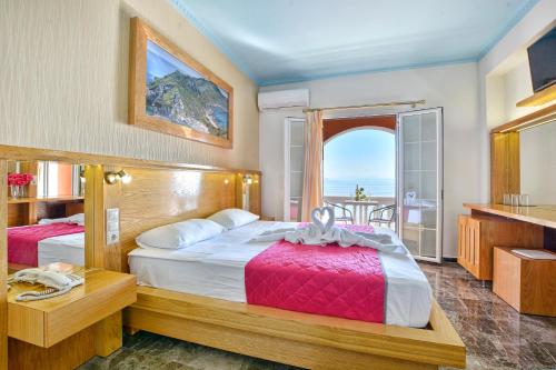 Lido Corfu Sun Hotel 4 Stars All-inclusive في بينيتسيس: غرفة نوم بسريرين وإطلالة على المحيط
