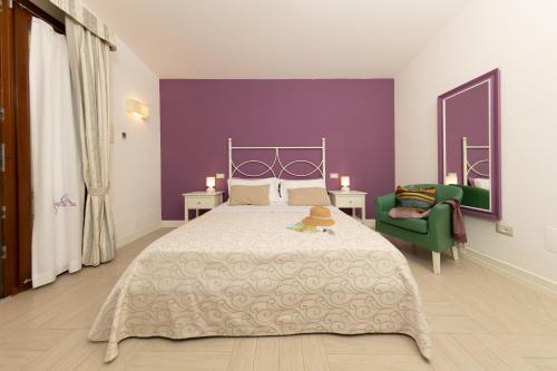 a bedroom with a large bed and a purple wall at Hotel Residence Il Porto in Mattinata