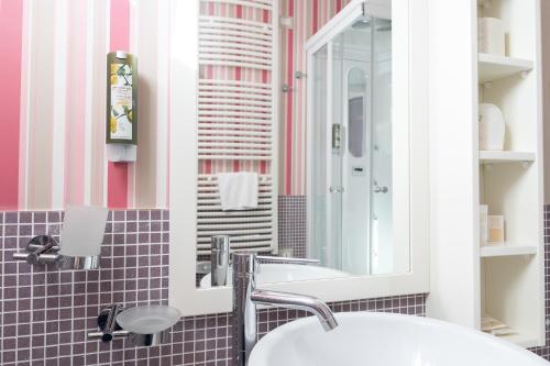 a bathroom with a sink and a mirror at Hotel Residence Il Porto in Mattinata